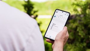 Hånd der holder en Samsung-telefon med tændt skærm